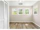 Bedroom featuring hardwood floors, neutral walls, and large windows offering views of mature trees at 1700 John Calvin Ave, Atlanta, GA 30337