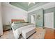 Spacious main bedroom with a tray ceiling, neutral walls, and light wood flooring at 210 Cole Ct, Canton, GA 30114