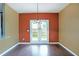 Open dining room with hardwood floors, red accent wall, and a double door to the backyard at 4354 Favored Way, Union City, GA 30291