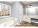 Bright bathroom with a soaking tub, large window, and vanity with countertop space at 495 Stratford Dr, Douglasville, GA 30134