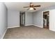 Spacious carpeted bedroom featuring a ceiling fan and access to other rooms at 495 Stratford Dr, Douglasville, GA 30134