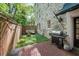 Cozy backyard with artificial turf, outdoor seating, string lights, brick patio, and grill at 65 Peachtree Memorial Nw Dr # 5, Atlanta, GA 30309