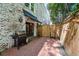 Brick patio with grill, awning, and string lights create a cozy outdoor space with partial privacy fence at 65 Peachtree Memorial Nw Dr # 5, Atlanta, GA 30309