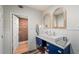 Updated bathroom with blue vanity, wooden framed mirrors, and doorway to another room at 65 Peachtree Memorial Nw Dr # 5, Atlanta, GA 30309
