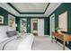 Green bedroom featuring a comfy bed, tray ceilings, and an ensuite bathroom, offering both style and convenience at 68 Spence Se Ave, Atlanta, GA 30317