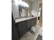 Modern bathroom with gray vanity, granite countertop, sleek mirror and tiled floors at 115 Winding River Dr # B, Atlanta, GA 30350