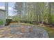 Backyard patio boasts a stone fire pit with a view of the wooded backyard at 302 Wickley Way, Woodstock, GA 30188