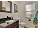 Bathroom features an ornate mirror, dark vanity, black granite countertop and framed art at 302 Wickley Way, Woodstock, GA 30188
