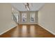 Versatile room with gleaming wood floors, large windows, and modern lighting fixture at 302 Wickley Way, Woodstock, GA 30188