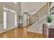 Inviting foyer with wood floors, staircase, and ample natural light streaming through the front door at 302 Wickley Way, Woodstock, GA 30188