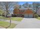 Charming two-story red brick home featuring an attached two-car garage and well-maintained landscaping at 302 Wickley Way, Woodstock, GA 30188