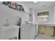 Bright laundry room with white appliances and built-in shelving for organizing essentials at 302 Wickley Way, Woodstock, GA 30188