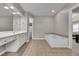 Large bathroom features a soaking tub, separate vanity, and lots of storage and tile floors at 302 Wickley Way, Woodstock, GA 30188