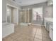 Spacious bathroom includes a walk-in shower, tiled floors, separate tub, and vanity at 302 Wickley Way, Woodstock, GA 30188