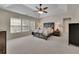 Spacious main bedroom with a tray ceiling, ceiling fan, and natural light from the windows at 302 Wickley Way, Woodstock, GA 30188