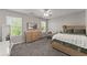 Neutral-toned bedroom featuring a bed, a dresser and a hanging papasan chair by the window at 3978 Oak Crossing Drive Dr, Suwanee, GA 30024