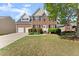 Charming two-story brick home with a well-manicured lawn, attached two-car garage, and inviting front entrance at 3978 Oak Crossing Drive Dr, Suwanee, GA 30024