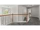 Upstairs hallway with carpet, a wooden railing, and a decorative light fixture at 3978 Oak Crossing Drive Dr, Suwanee, GA 30024