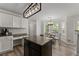 Well-lit kitchen and breakfast nook featuring white cabinets, granite countertops, and a chandelier at 3978 Oak Crossing Drive Dr, Suwanee, GA 30024