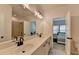 Stylish bathroom features a double sink vanity, large mirror, modern lighting, and a door to the bedroom at 4409 Encore Park Lane, Duluth, GA 30097