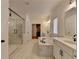 Luxurious bathroom featuring a soaking tub, glass-enclosed shower, double vanity, and elegant marble tile floors at 4409 Encore Park Lane, Duluth, GA 30097