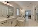 This bathroom has double sinks, a soaking tub, tiled floors, and a seamless glass shower at 4409 Encore Park Lane, Duluth, GA 30097