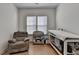 Comfortable Bedroom featuring a cozy armchair, changing table, and crib with natural light at 4409 Encore Park Lane, Duluth, GA 30097
