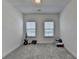 Bright bedroom with two windows, gray carpet, and white walls offers a clean and adaptable living space at 4409 Encore Park Lane, Duluth, GA 30097