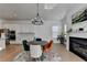 Open concept dining area with modern chandelier, fireplace, and a stylish kitchen with stainless appliances at 4409 Encore Park Lane, Duluth, GA 30097