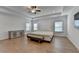 Bright, spacious main bedroom featuring hardwood floors, tray ceilings, a ceiling fan, and ample natural light at 4409 Encore Park Lane, Duluth, GA 30097