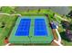 Overhead shot of community tennis courts with a shelter, surrounded by green lawns at 4409 Encore Park Lane, Duluth, GA 30097