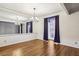 Dining room featuring wood floors, white walls with a mirror wall, chandelier, and window with dark curtains at 45 Willow Ne Gln, Atlanta, GA 30342