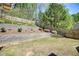 Professionally landscaped backyard with multi tiered retaining walls and lush greenery at 453 Thorn Creek Way, Dallas, GA 30157