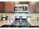 Close up shot of a kitchen showcasing stainless steel appliances, a gas range, and granite countertops at 453 Thorn Creek Way, Dallas, GA 30157