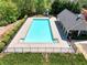Community pool with a bright blue interior, steps for access, and a surrounding fence for safety at 453 Thorn Creek Way, Dallas, GA 30157