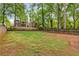 Expansive, grassy backyard surrounded by mature trees and a wooden fence, offering privacy and space at 60 Spence Se Ave, Atlanta, GA 30317