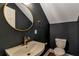 Chic powder room with a modern round mirror, stylish fixtures, and elegant dark wall, a classic design at 60 Spence Se Ave, Atlanta, GA 30317