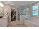 Bright bathroom featuring a glass-enclosed shower, soaking tub, and a view into a walk-in closet at 60 Spence Se Ave, Atlanta, GA 30317