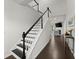 Elegant staircase featuring dark wood treads and white risers complemented by modern black railings at 216 Ellis Ln, Woodstock, GA 30189