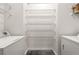 Bright laundry room featuring white washer and dryer with multiple wire shelves for storage and organization at 250 Pharr Ne Rd # 905, Atlanta, GA 30305