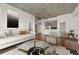 Living room featuring a sleek sofa, modern artwork, and an open concept view into the kitchen at 250 Pharr Ne Rd # 905, Atlanta, GA 30305