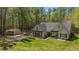 Aerial view of a charming home with a large lawn, storage shed, and surrounded by mature trees at 285 Willow Shoals Dr, Covington, GA 30016
