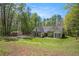 Picturesque home with lush green lawn and a storage shed, surrounded by mature trees at 285 Willow Shoals Dr, Covington, GA 30016