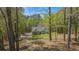 Scenic view of a charming home nestled among mature trees with a winding driveway at 285 Willow Shoals Dr, Covington, GA 30016