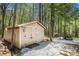Exterior of a storage outbuilding situated among towering trees, providing ample storage space at 285 Willow Shoals Dr, Covington, GA 30016