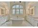 Beautiful bathroom featuring double sinks, vanity, tile floors and a free-standing tub at 4505 Whitestone Way, Suwanee, GA 30024
