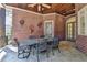 Spacious covered patio with brick walls, stone floors and comfortable dining area at 4505 Whitestone Way, Suwanee, GA 30024