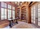 Sophisticated home office with wood paneling, built-in bookshelves, and large windows at 4505 Whitestone Way, Suwanee, GA 30024