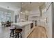 Elegant kitchen featuring white cabinets, a large island, stainless steel appliances, and breakfast table at 4505 Whitestone Way, Suwanee, GA 30024