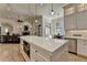 Open-concept kitchen featuring a large island and a view into the living room with fireplace at 4505 Whitestone Way, Suwanee, GA 30024